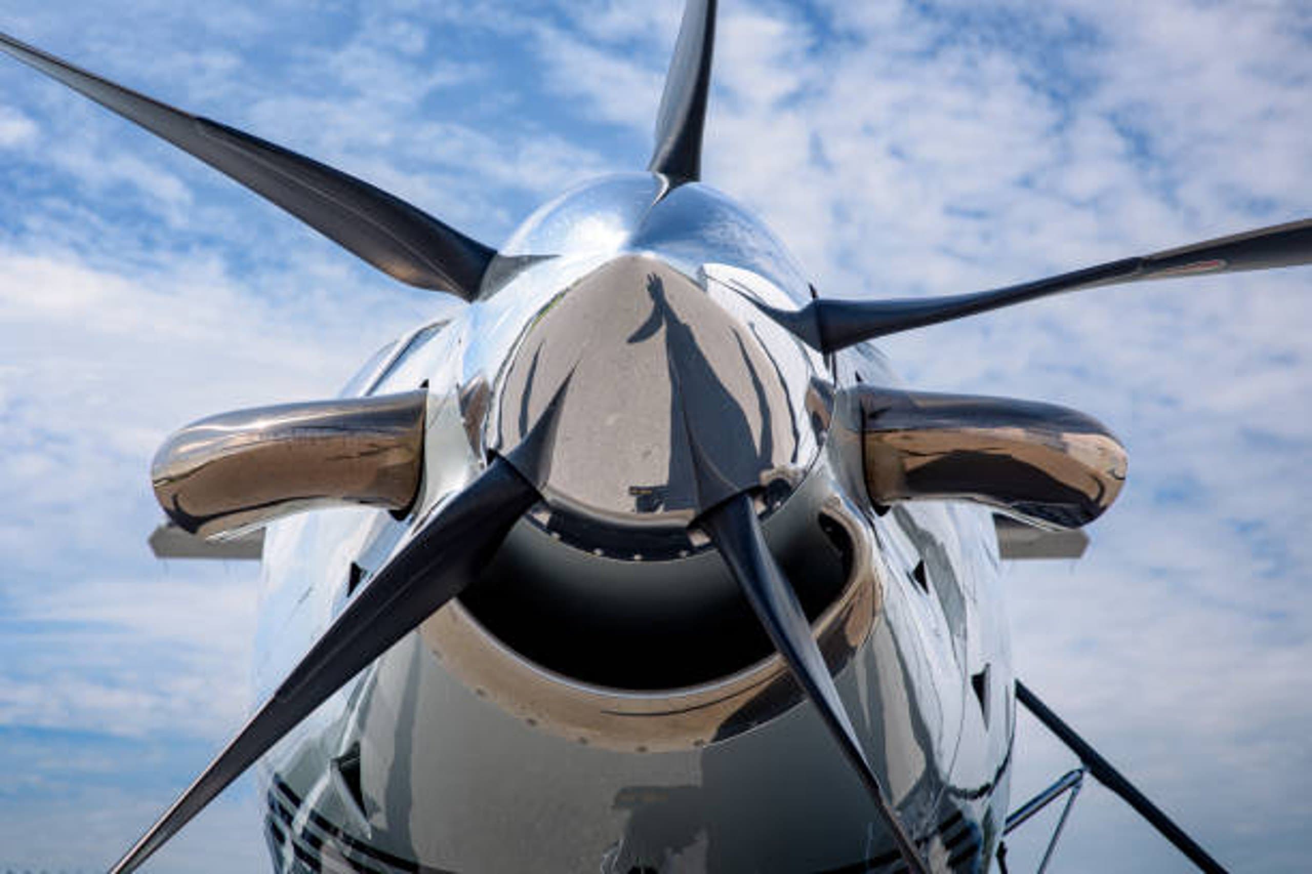 Nahaufnahme eines Flugzeugpropellers mit vier Blättern und glänzender Nabe